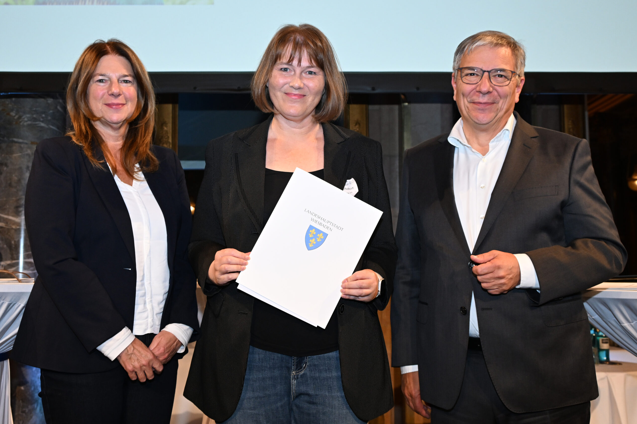 Für die Gartenbau-Versicherung nahm Nachhaltigkeitsbeauftragte Anette Raschdorf (Mitte) die Urkunde von Oberbürgermeister Gert-Uwe Mende und Bürgermeisterin Christiane Hinninger entgegen. (Foto Kristina Schäfer)